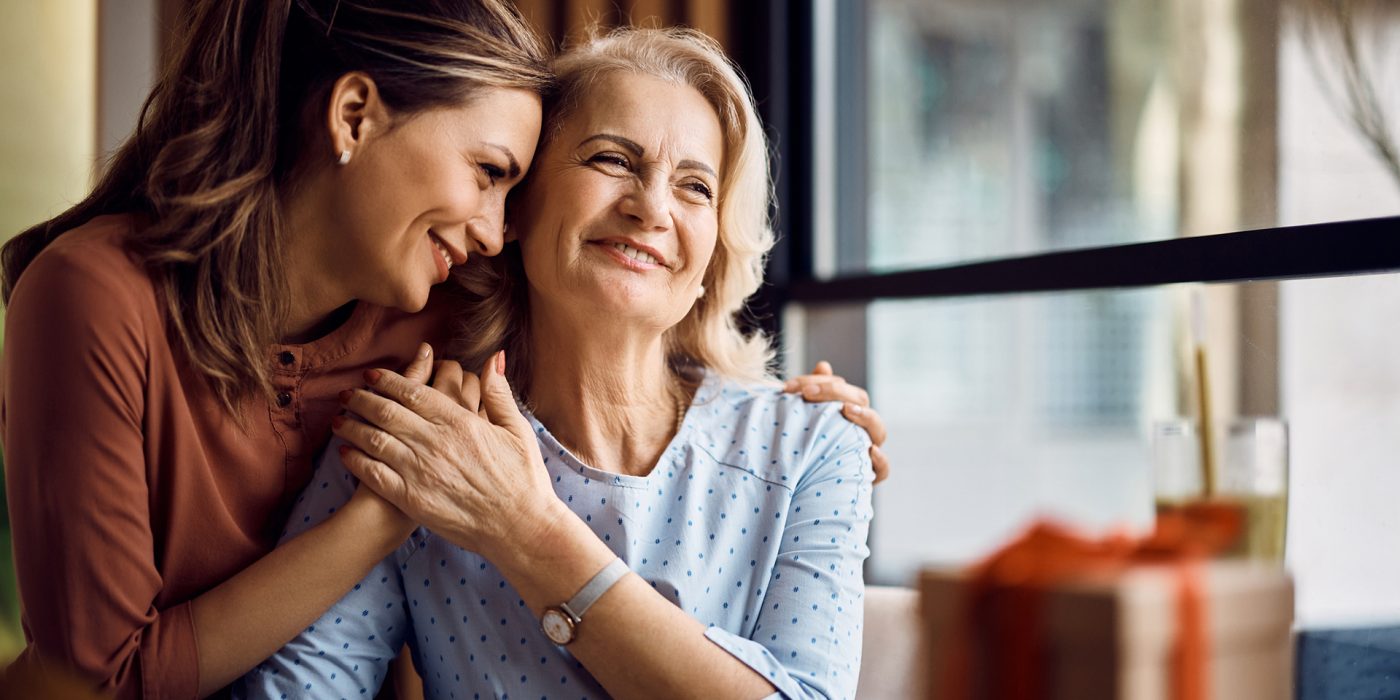 senior woman and adult daughter hugging