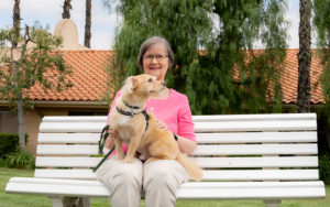 woman enjoying her move to senior living with her dog outside